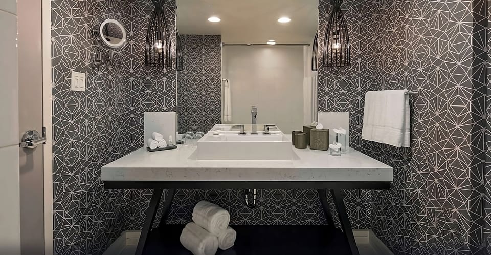 Refresh in a designer bath with bright vanity lighting.
