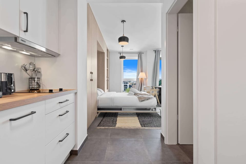 Inviting hallway with modern lighting, leading to a cozy bedroom and living area.