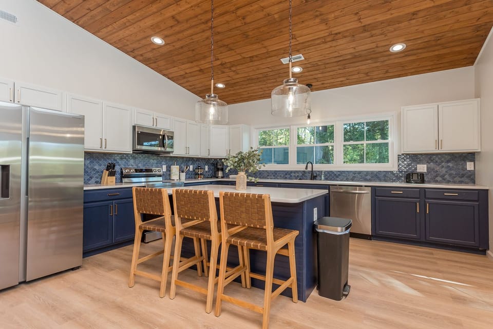 Updated kitchen featuring stainless steel appliances, ample cabinetry, and Quartz Countertops. Fully equipped with essentials including a drip coffee maker, crockpot, blender, toaster, dinnerware, glassware, silverware, and a wide array of cookware, pots, and pans.