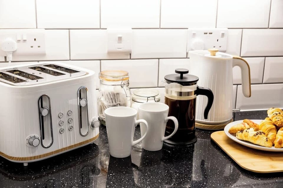 Start your day with coffee, tea, and fresh pastries in this stylish kitchen setup.