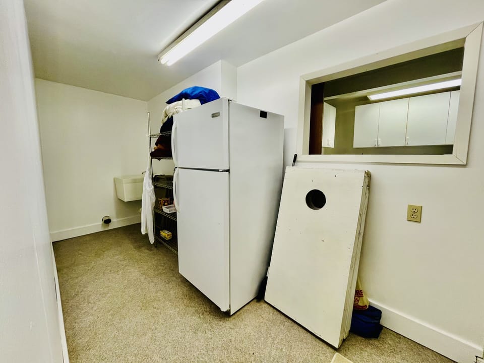 Fridge with freeze, industrial sink, and extra supplies, bedding, and towels. 