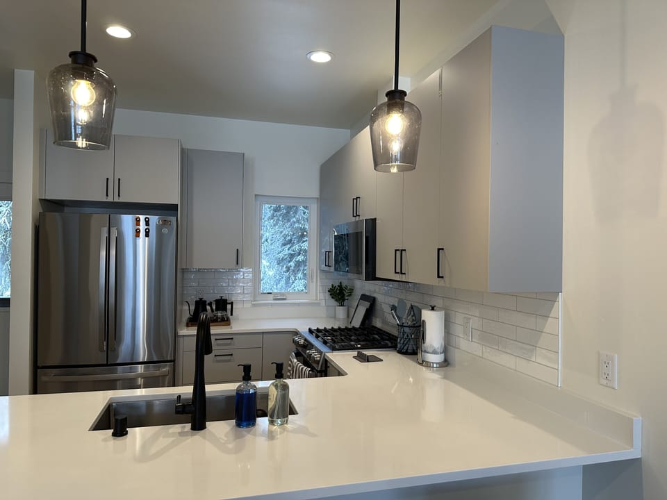 Kitchen has counter seating for three. Large fridge has ice maker in freezer. 