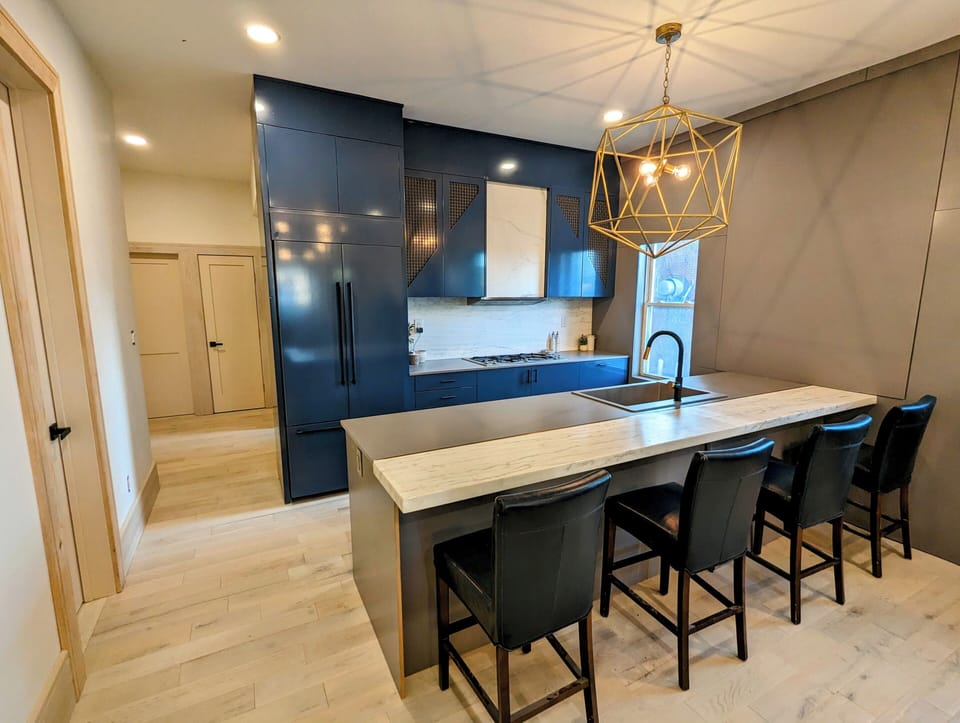 Custom Kitchen boasts stunning navy cabinetry, high-end appliances & marble