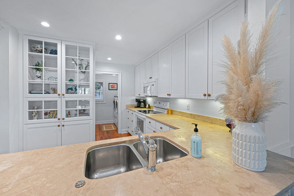 Spacious kitchen with ample counter space, a double sink, and seamless flow to the laundry area—making meal prep and everyday living simple and convenient.