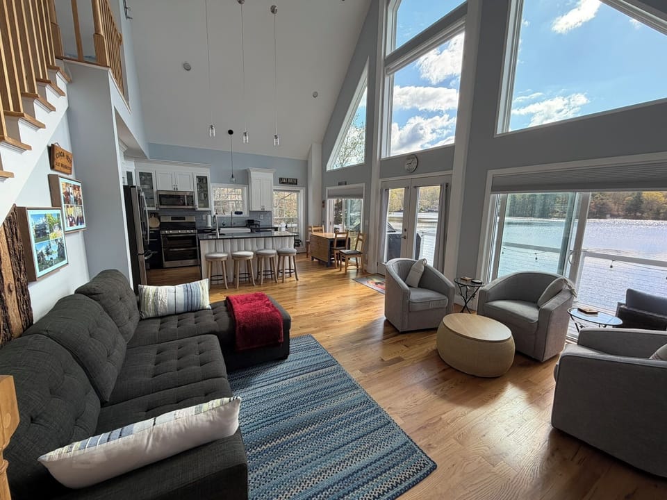 Great room with sectional, cozy swivel chairs, generous bar seating, kitchen.