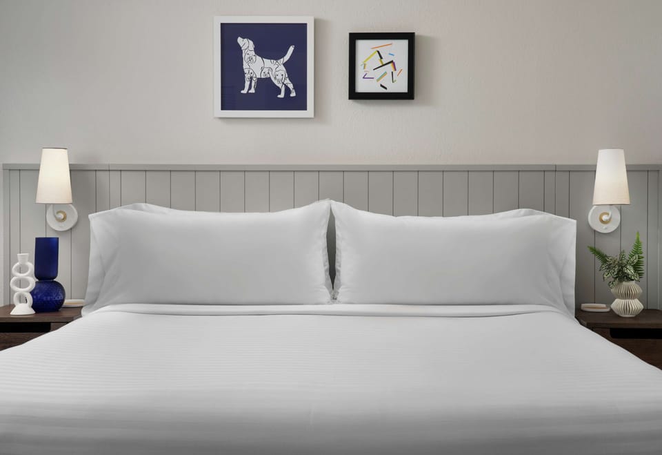 Drift off in crisp linens with calming, modern bedside lighting.