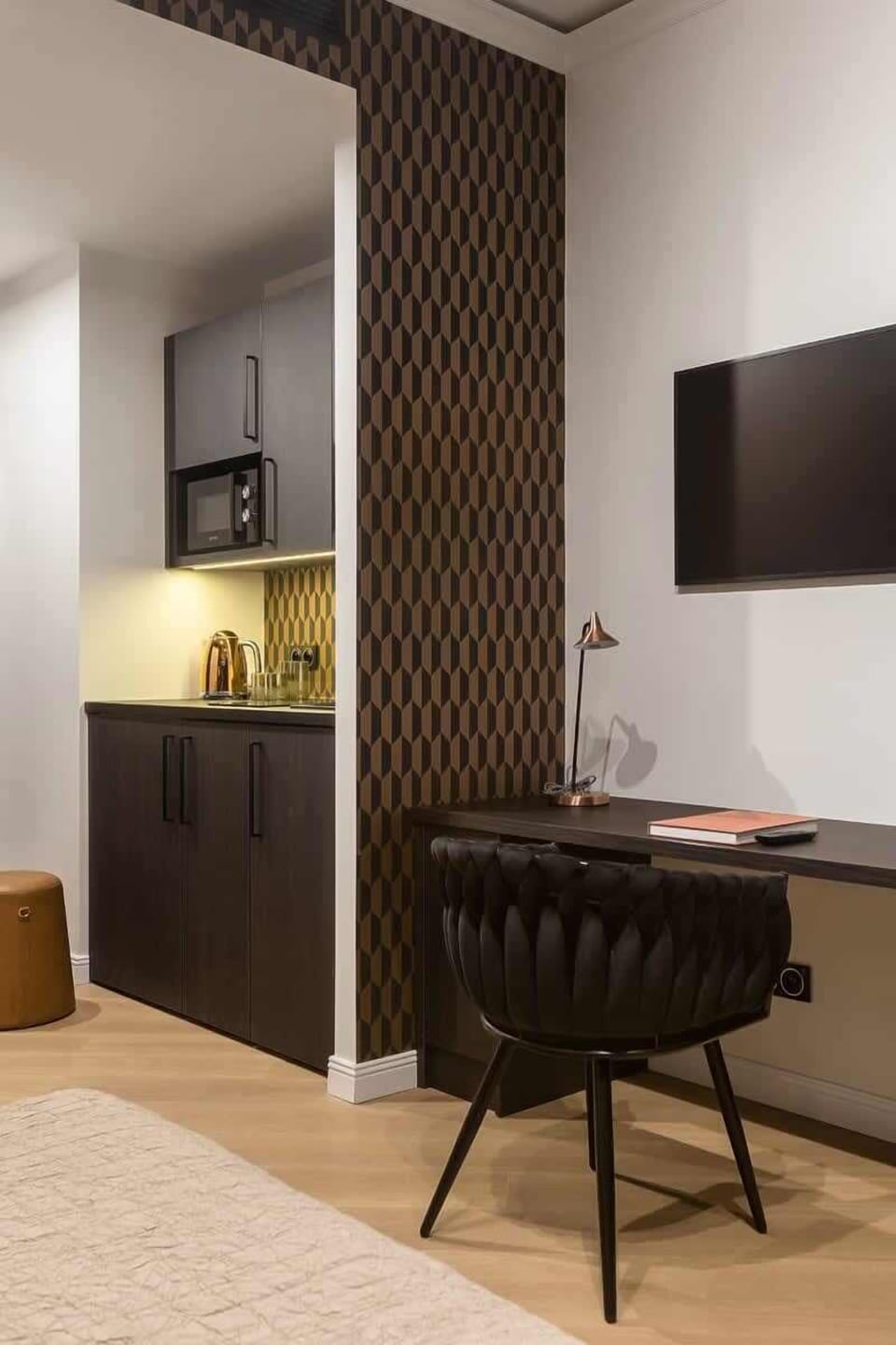A different angle of the same bedroom, highlighting a sleek dresser against a patterned accent wall.

