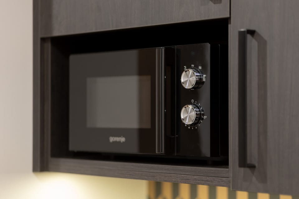 A close-up of the built-in microwave featuring a sleek black and metallic finish.







