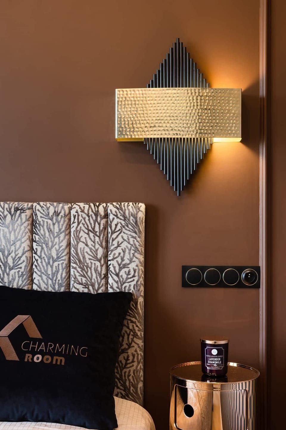 A decorative lamp and wall detail near the bed, adding charm and elegance to the room.

