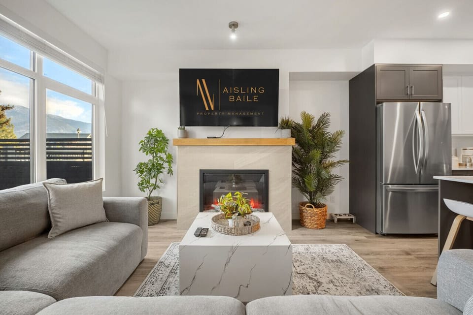 Living room with a gas-lit fireplace, Smart TV, a cozy sectional and walkout access to the backyard/hot tub.