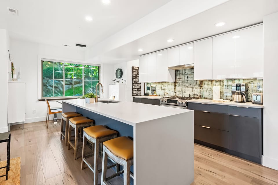 - Cook in a sleek kitchen with stainless appliances  
- Spacious island with bar stools for casual meals  
- Bright window view makes the space feel inviting
