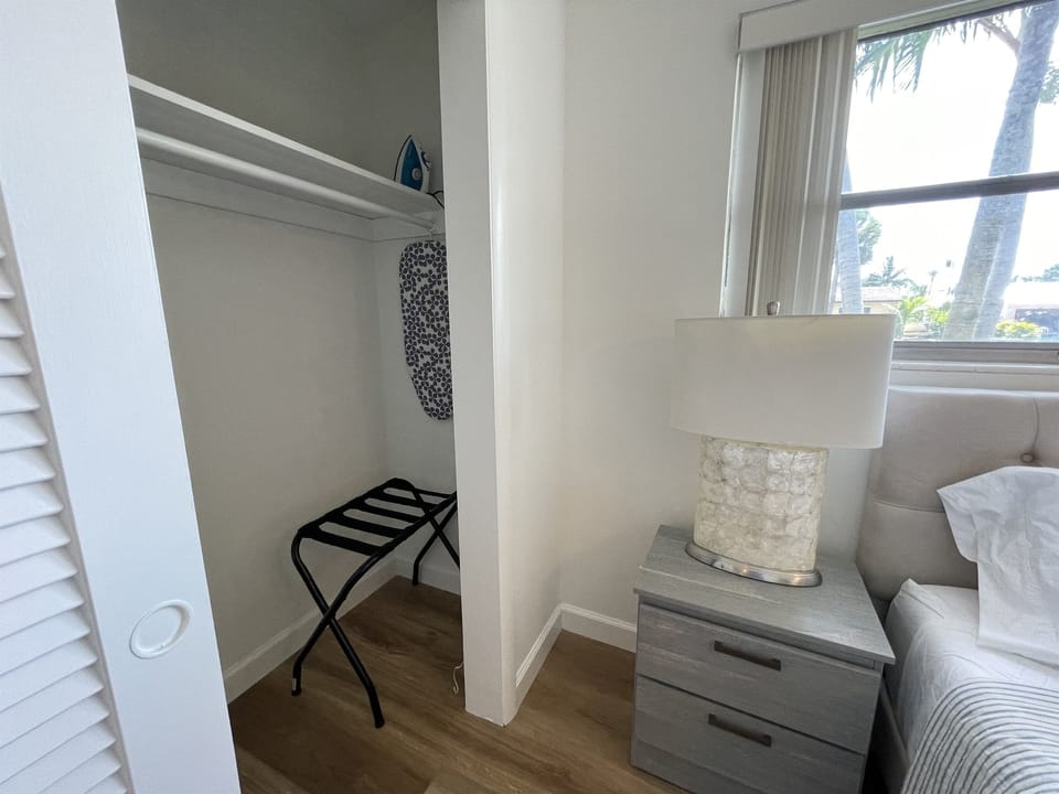 The master bedroom closet offers a convenient luggage rack, iron, and ironing board for your stay. Plus, enjoy a second luggage rack in the second guest bedroom, ensuring you have everything you need for a comfortable and organized visit