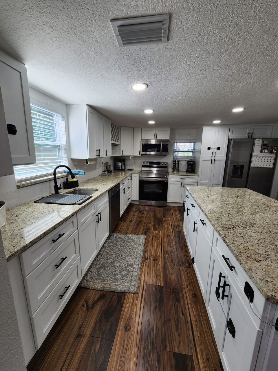 Bright full kitchen with large island, stocked essentials and open storage.