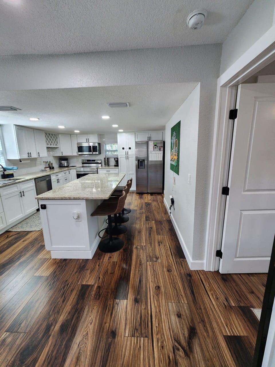 Bright full kitchen with large island, stocked essentials and open storage.