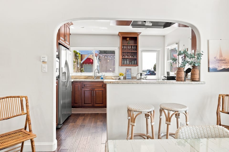 Bright open kitchen with breakfast bar, wood cabinetry, and natural light