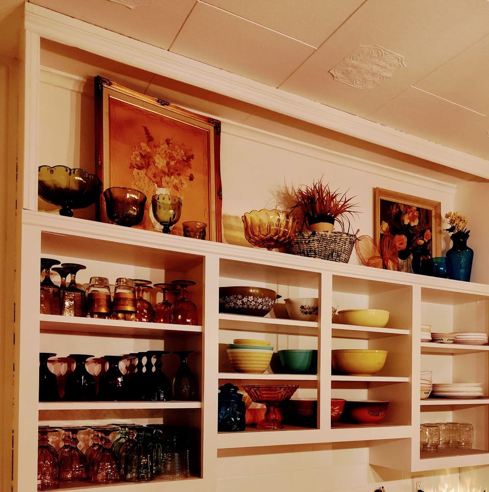 This is the original kitchen with hardwood floors, fire place and ceiling tiles.