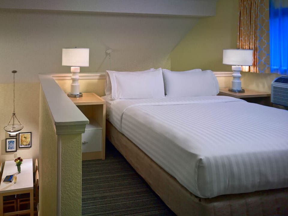 Recharge upstairs in a quiet loft bedroom with soft glow.