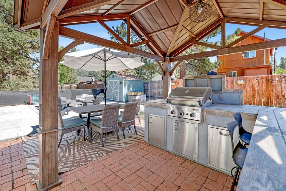 Spacious backyard with a relaxing hot tub, BBQ, outdoor dining area, comfy seating, perfect for peaceful evenings outdoors.