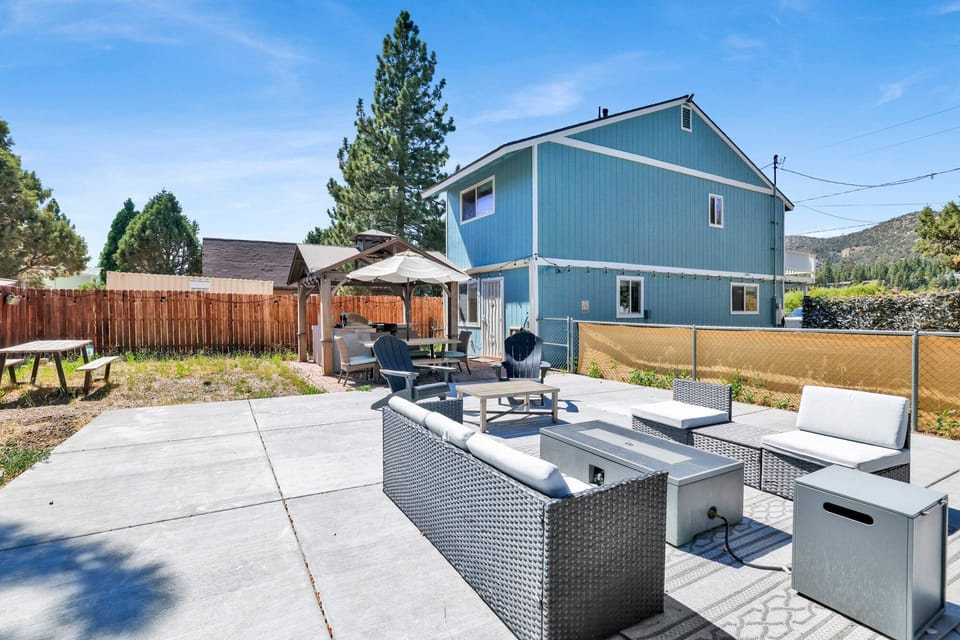 Spacious backyard with a relaxing hot tub, BBQ, outdoor dining area, comfy seating, perfect for peaceful evenings outdoors.