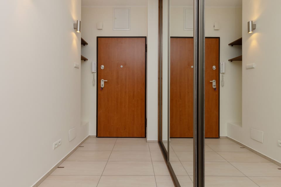 A mirror in the hallway with reflective surfaces and well-organized lighting.

