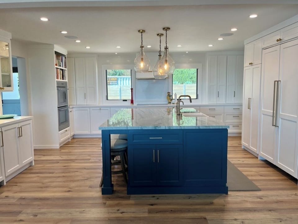 Oversized island with custom kitchen cabinetry and unique pendant lights