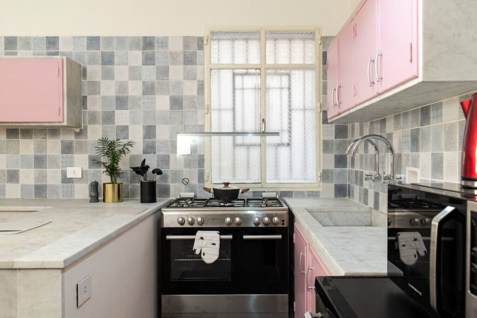 A highly functional kitchen setup perfect for longer stays. Enjoy modern appliances, ample prep space, and a unique retro checkered tile backdrop.