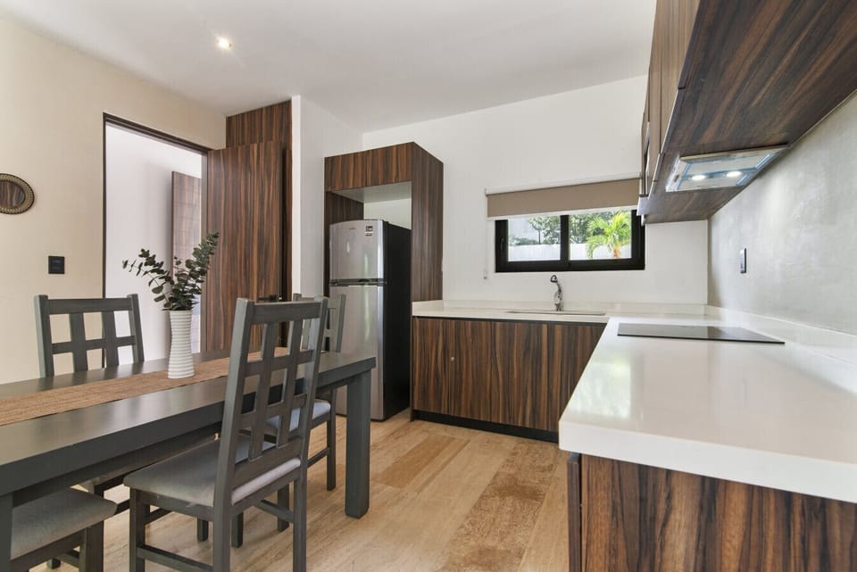 Stylish kitchen with sleek cabinetry, modern fridge, and dining area.
