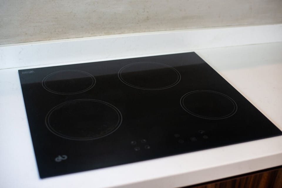 Modern kitchen with induction cooktop and sleek black glass surface.