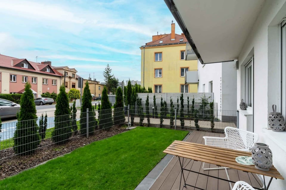 A backyard view featuring a private outdoor space with grass, decking, and seating.

