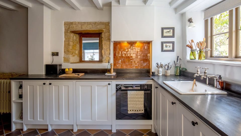 Thereâ€™s a full oven, hob, dishwasher, and a fridge hidden behind sleek white cupboards.