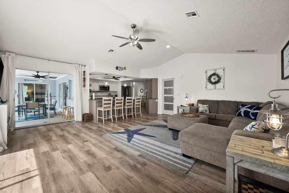 Large main living area with sectional couch access to pool with two sliders