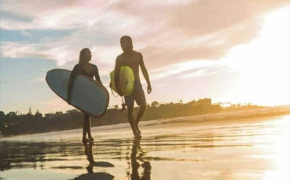 Surfers at sunset on San Diego beaches nearby for morning surf checks and mellow walks
