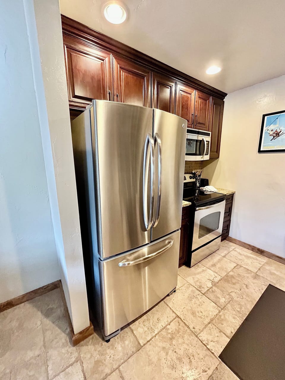 Stainless steel fridge, oven and microwave in kitchen.