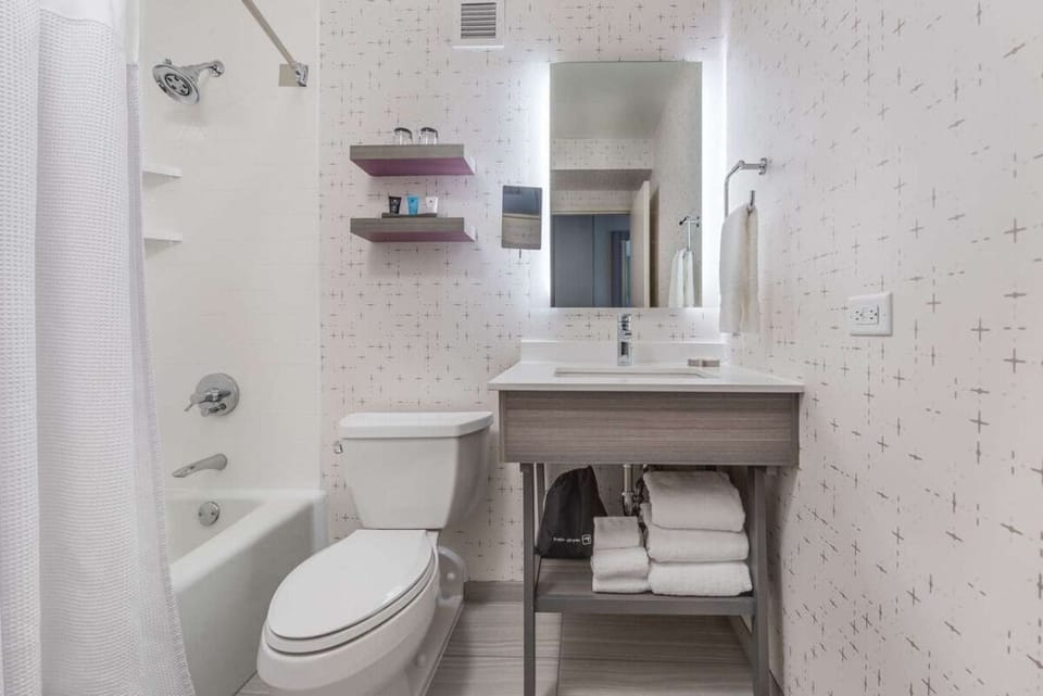Refresh easily with bright vanity, fluffy towels, and tub-shower.