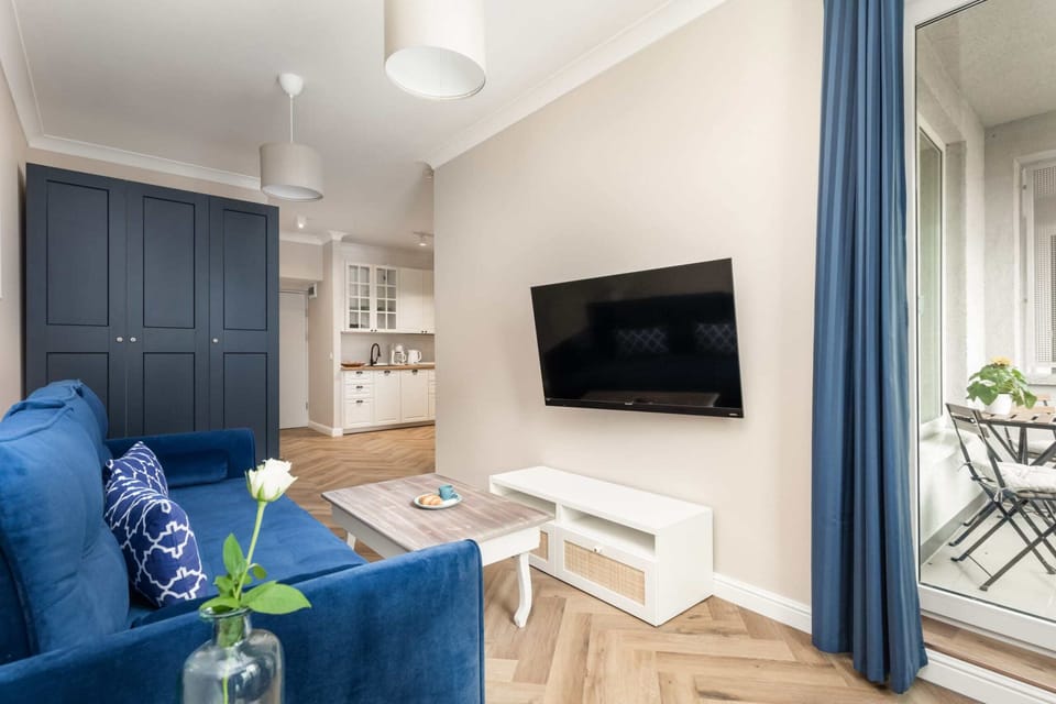 Another angle of the living area with the blue sofa, showcasing a mix of comfort and style.

