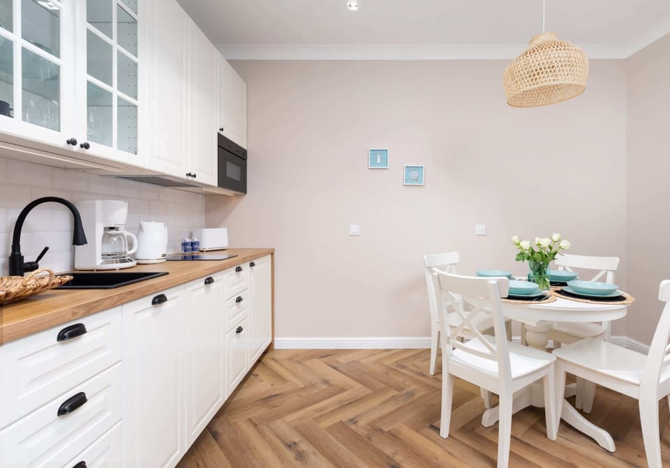 The dining area with a wooden table, elegant white chairs, and a decorative centerpiece.

