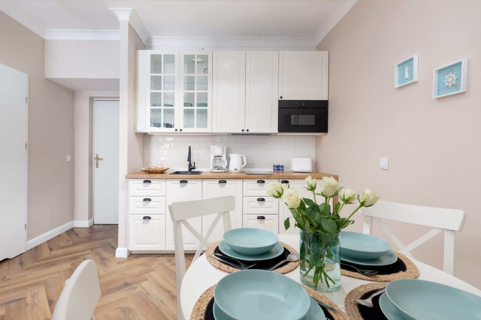 A kitchen counter with a white coffee maker, mugs, and convenient cooking essentials.

