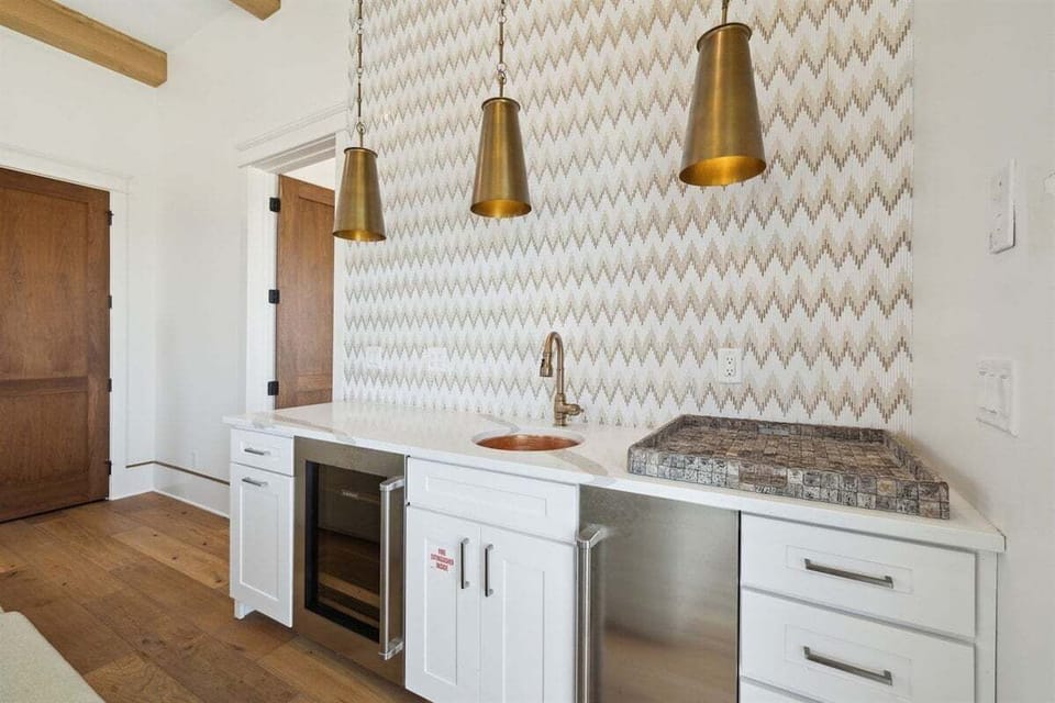 This stylish wet bar with a built-in icemaker and beverage cooler makes it perfect for entertaining. Conveniently located near the pool with direct outdoor access.