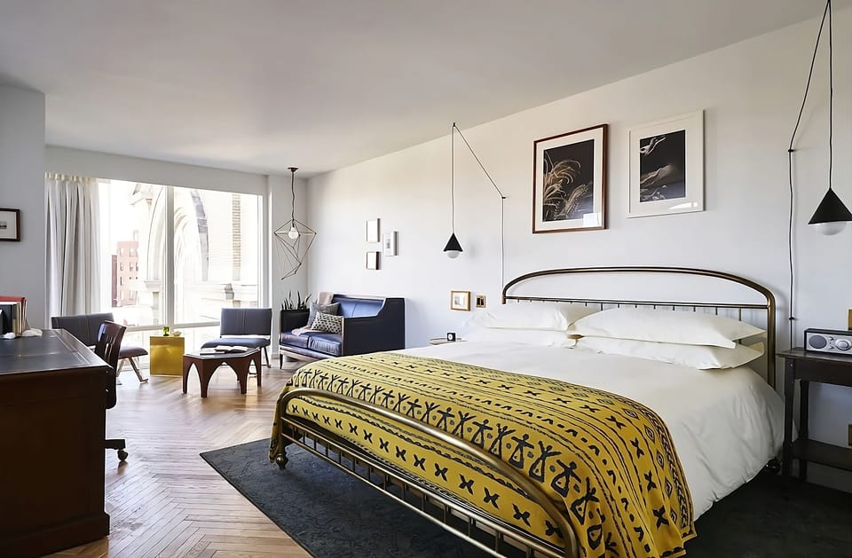 Unwind in a sunlit bedroom with chic city-side lounging.