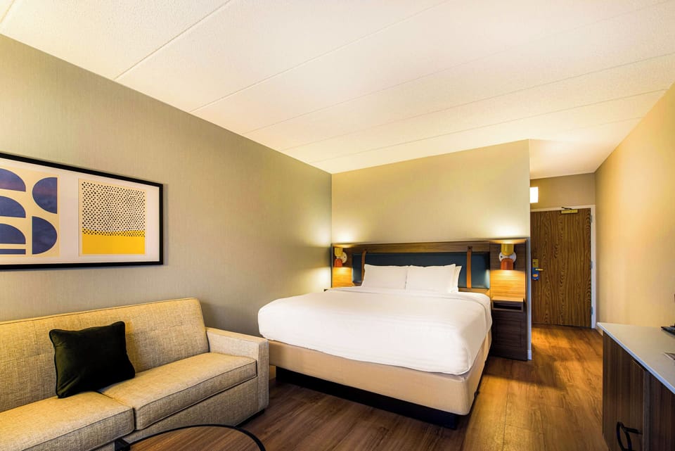 Relax in a calm, modern room with sofa and plush bed.