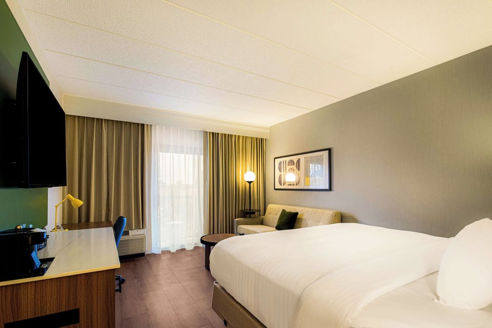 Unwind in a bright room with plush bed and lounge seating.