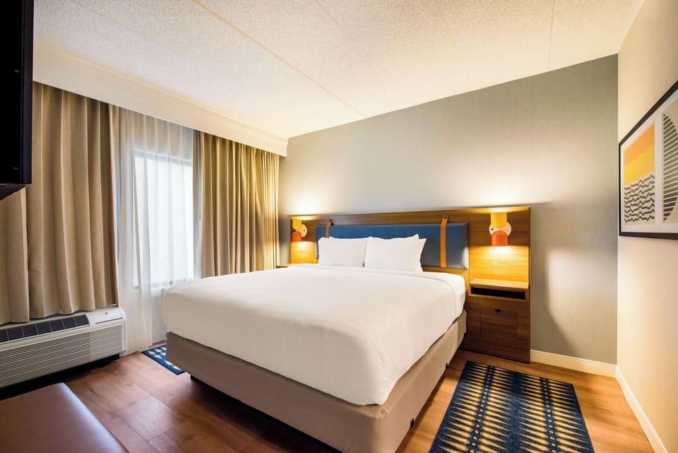 Sink into a plush king bed under warm lighting.