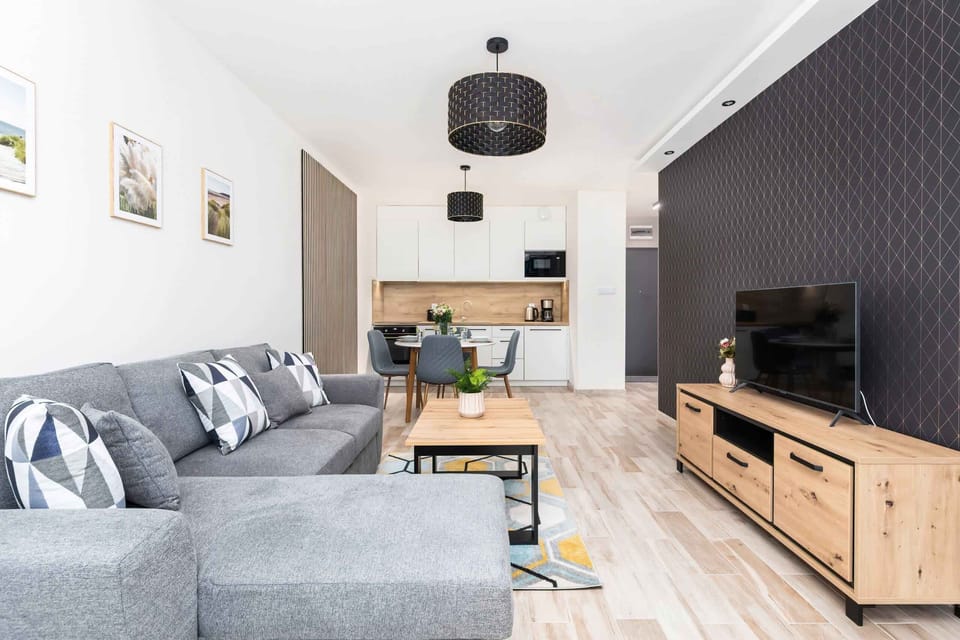 Another angle of the living room with a large TV, stylish shelving, and comfortable seating, ideal for relaxing or entertaining guests.

