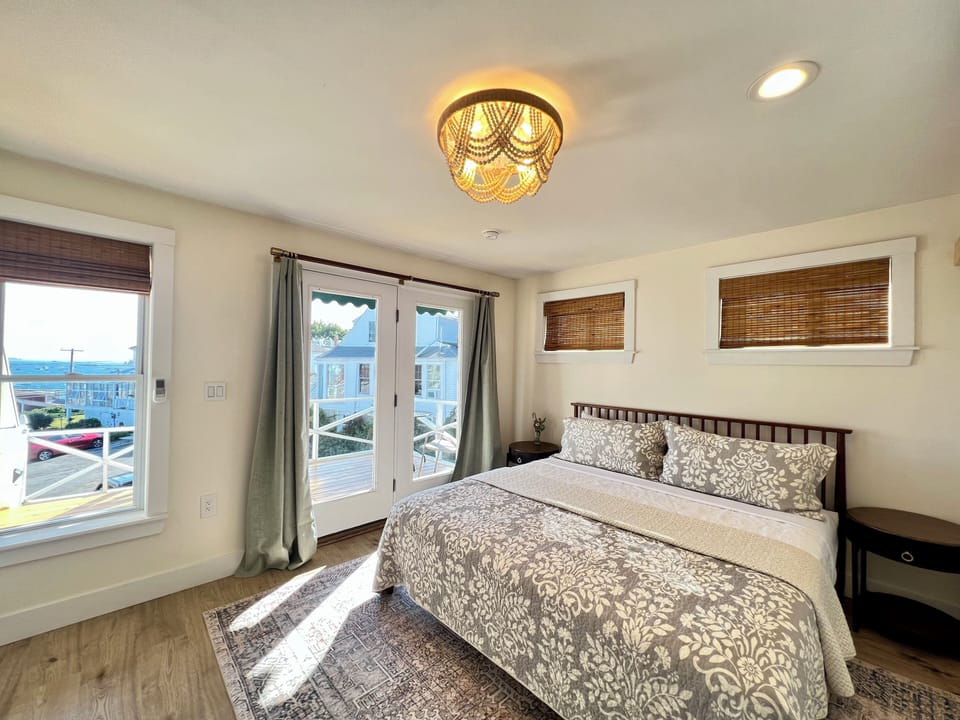 Enjoy stunning Boothbay Harbor views from this serene king room, featuring French doors to a private deck, cozy coastal décor, and fresh sea air—all just steps from downtown.
