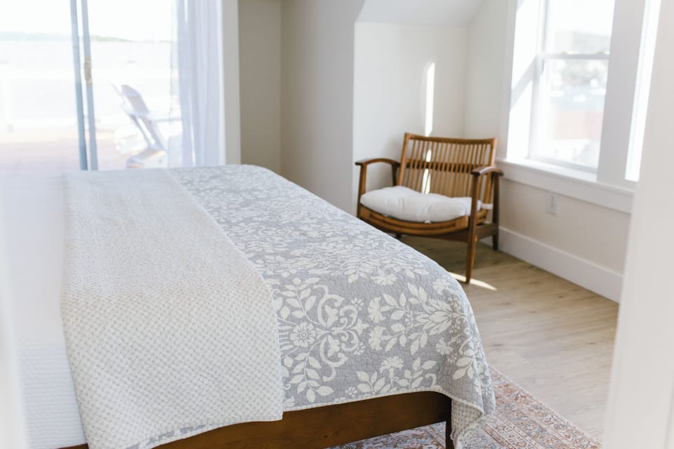 Greenleaf Room 7 offers a peaceful retreat with a plush king bed, soft natural light, and private access to the rooftop deck. Clean lines, a comfy sitting area, and coastal charm make it a guest favorite in Boothbay Harbor, Maine.
