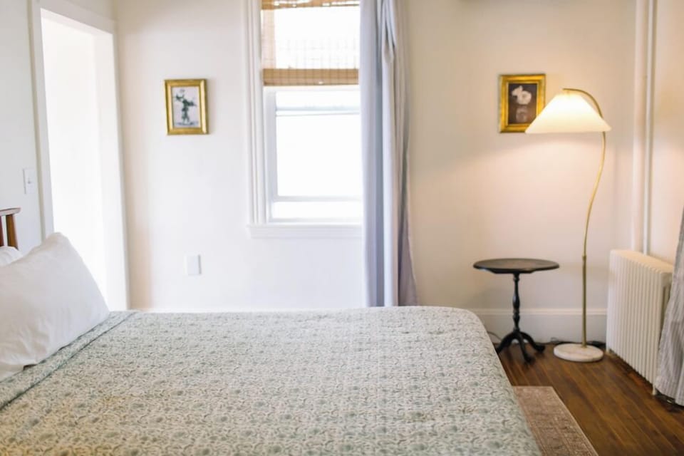Room 13 offers soft lighting, vintage artwork, and cozy charm in a sun-filled king bedroom—perfect for a restful night after exploring the sights of Boothbay Harbor.