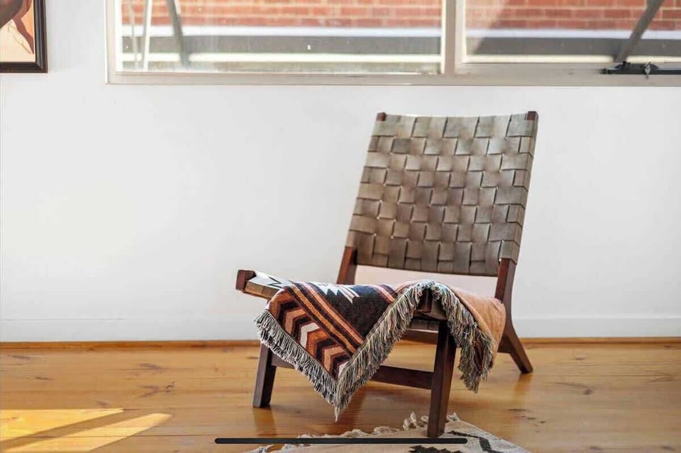 Find your quiet corner in this cozy spot, perfect for unwinding with a good book. This inviting chair, complemented by stylish decor, offers a comfortable retreat within your stay.