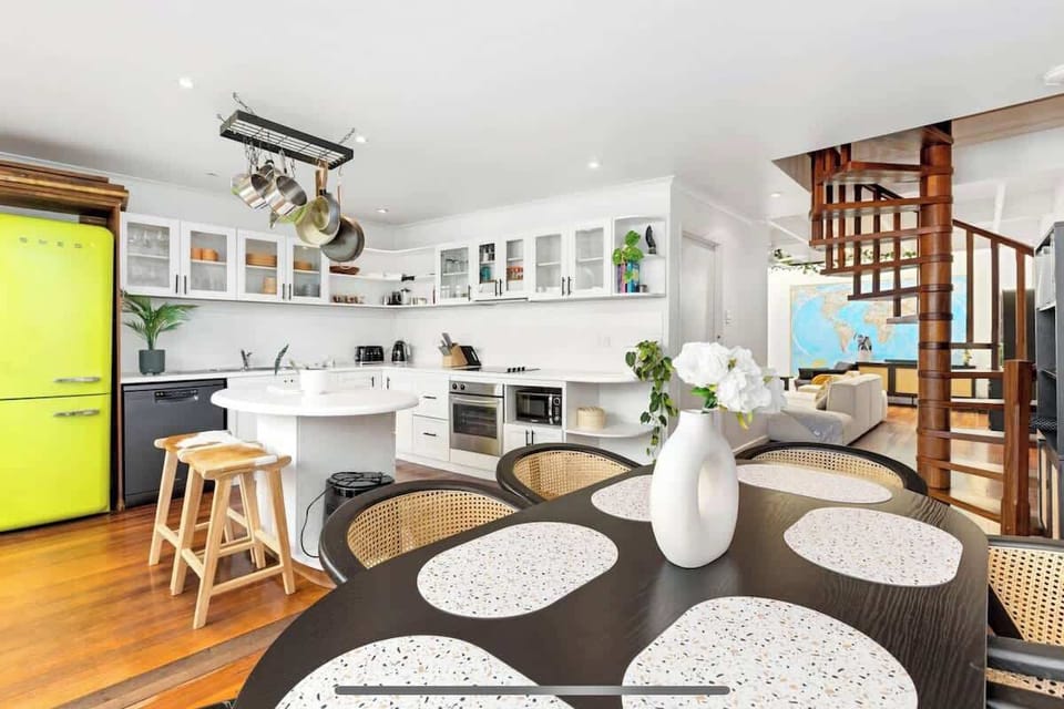 Whip up meals effortlessly in our combined dining and kitchen area! Featuring a dining table, kitchen island, microwave, oven, sink, fridge, and ample cabinets.