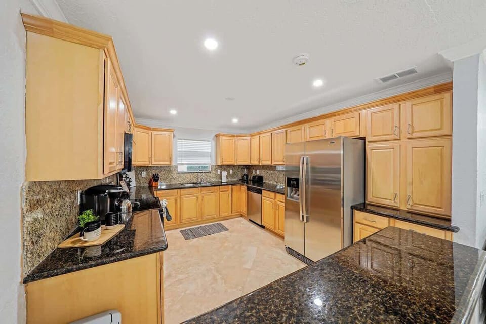 The kitchen features modern stainless steel appliances, including a refrigerator, stove/oven, and microwave. These appliances are thoughtfully arranged for efficient use and easy access, ensuring a seamless cooking experience. 