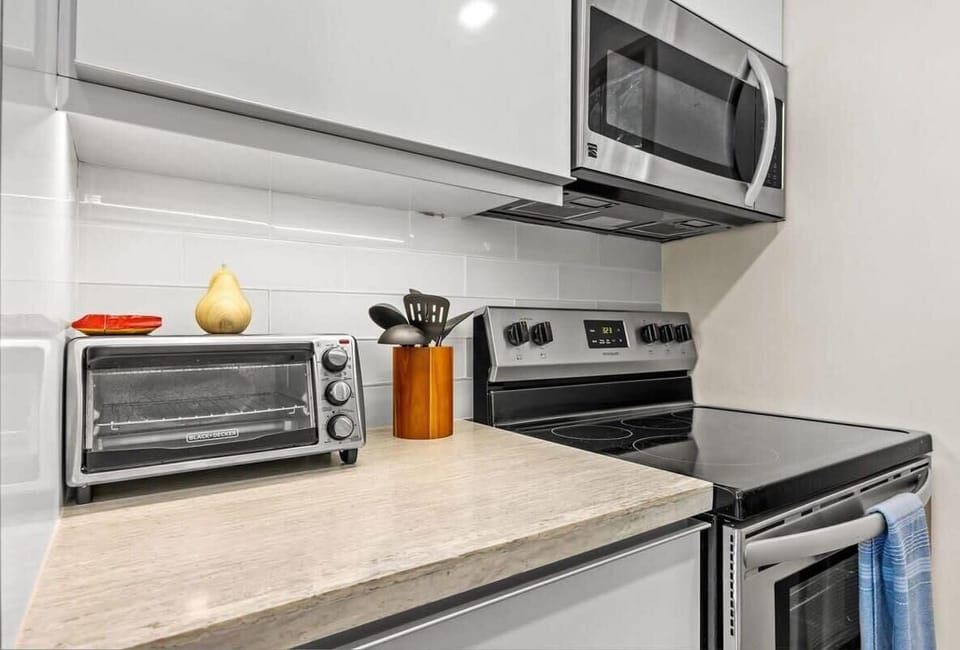 Kitchen has a stove, oven, microwave and toaster oven